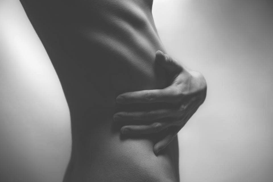 Main posée sur la taille, silhouette en clair-obscur