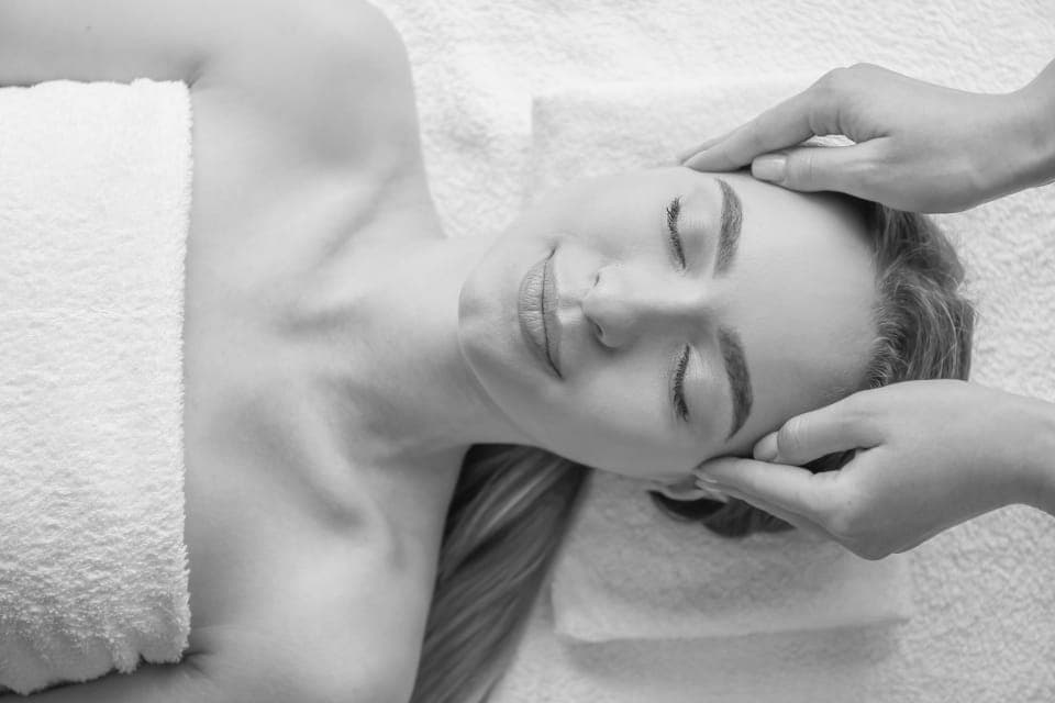 Soin du visage, la patiente allongée les yeux fermés