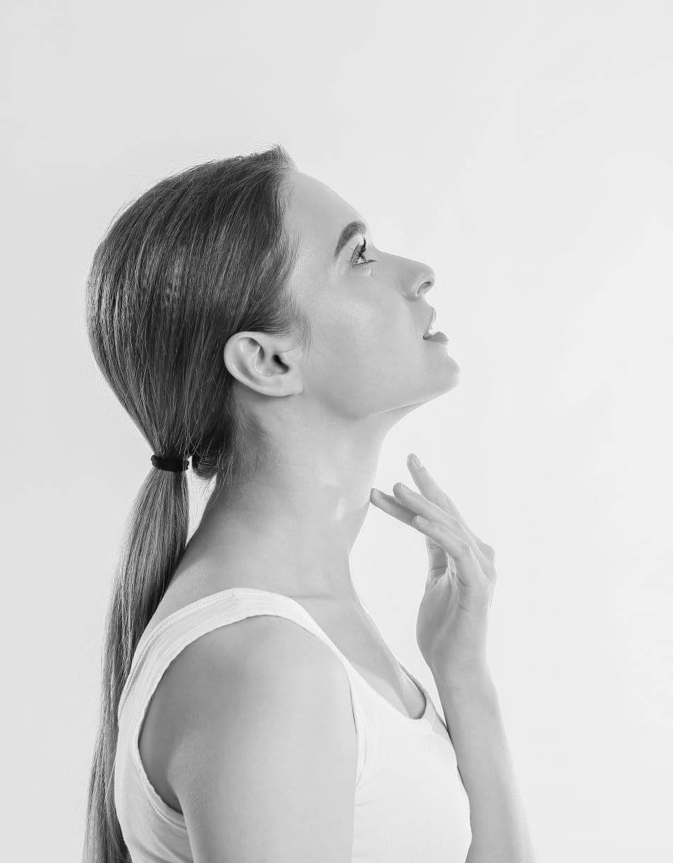 Profil d'une femme, la main effleurant le cou et l'ovale du visage
