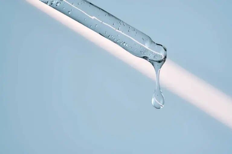 Goutte de gel au bout d’une pipette, sur fond clair